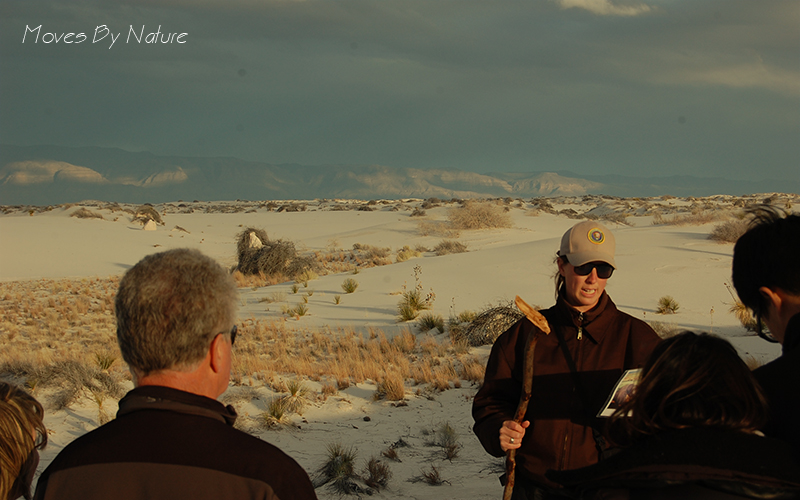Park ranger is talking to a group of people in the dunes of White Sands