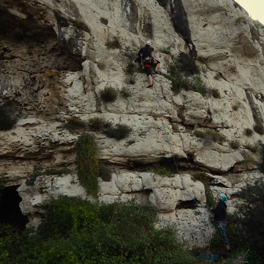 Woman climbing and a woman belaying in Malta